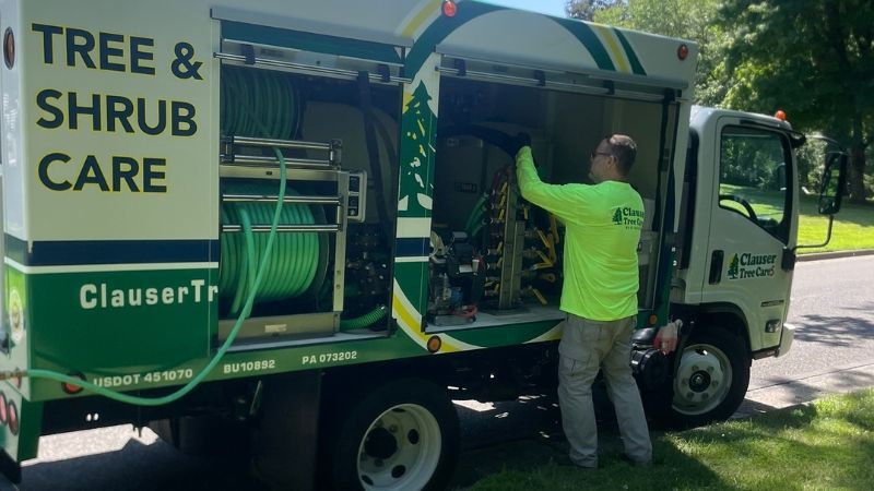Clauser Tree Care technician preparing tree and shrub care equipment in company truck.